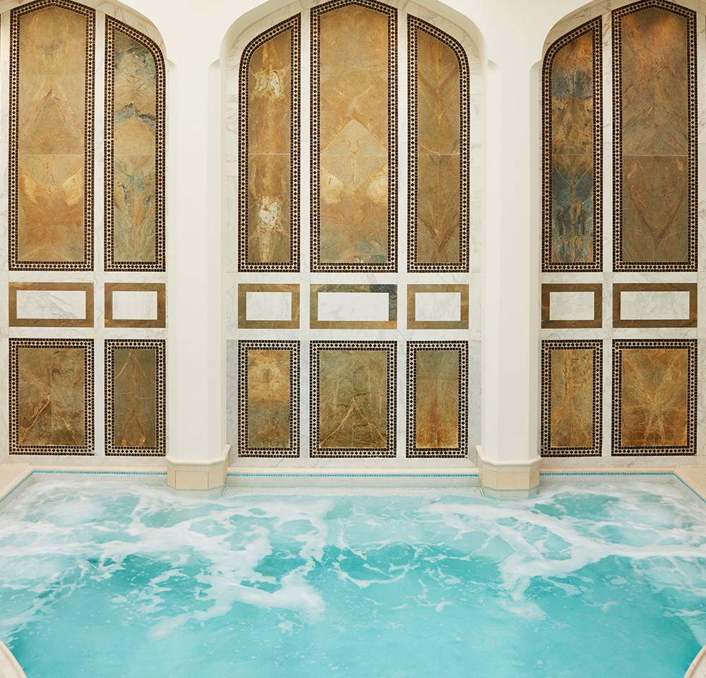 A large immersion pool at a spa with mosaic walls