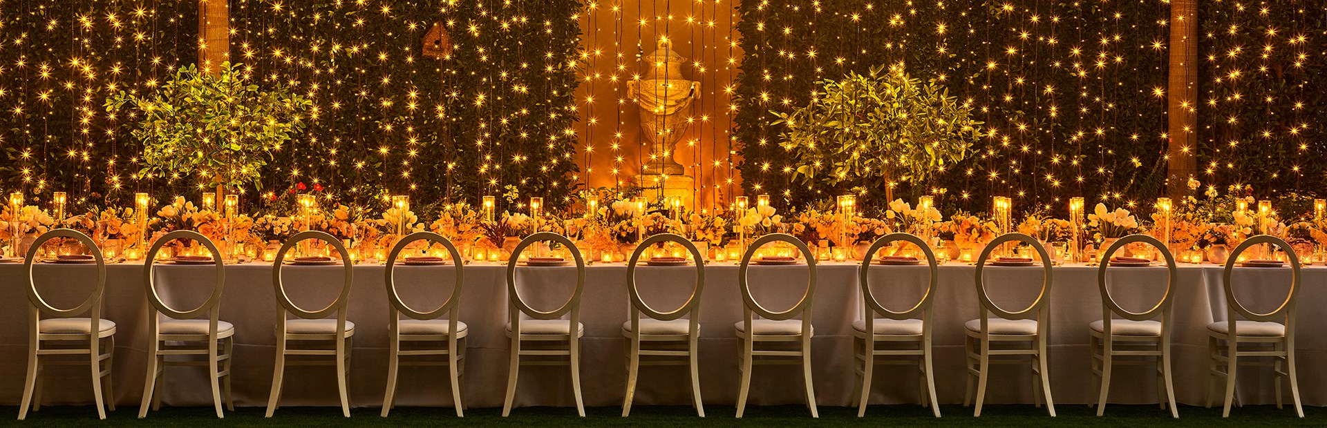 Long rectangular dining table with dangling lights at The Garden Terrace at The Maybourne Beverly Hills