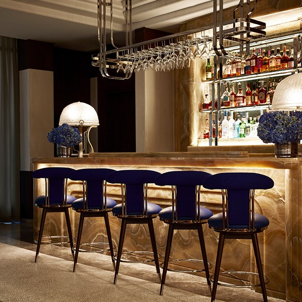 Five cozy chairs arranged in front of the bar counter, bathed in soft, dim light.