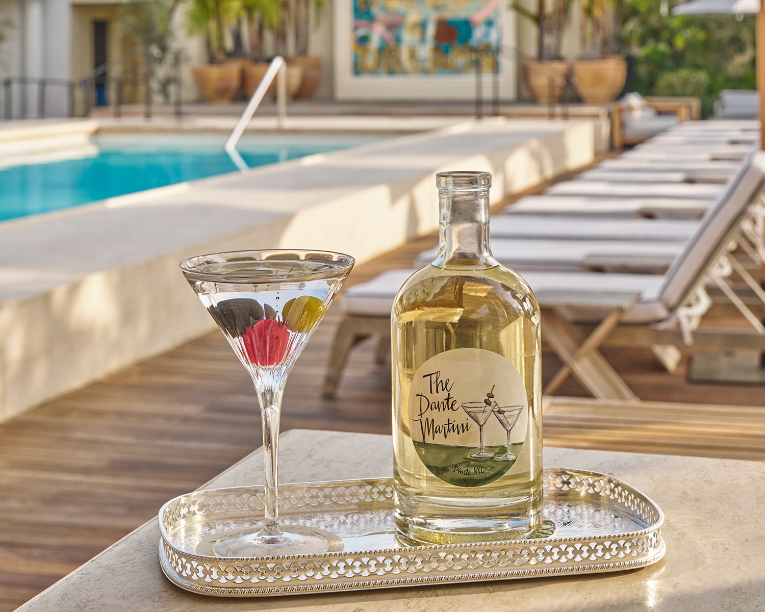 Martini on a silver tray with swimming pool in the background