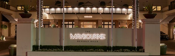 The Maybourne Beverly Hills light lit up with palm trees either side