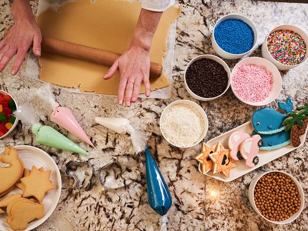 Cookie making ingredients laid out including sprinkles, sweets and piping icing