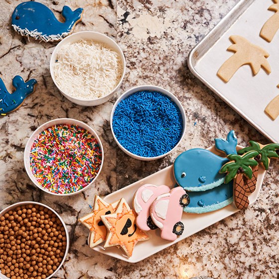 Cookie making ingredients laid out including sprinkles, sweets and piping icing