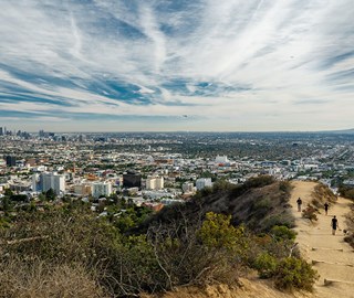 Sweeping views over Los Angeles city from a mountain hike trail with people walking