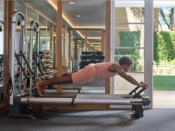 Man using reformer pilates machine in gym