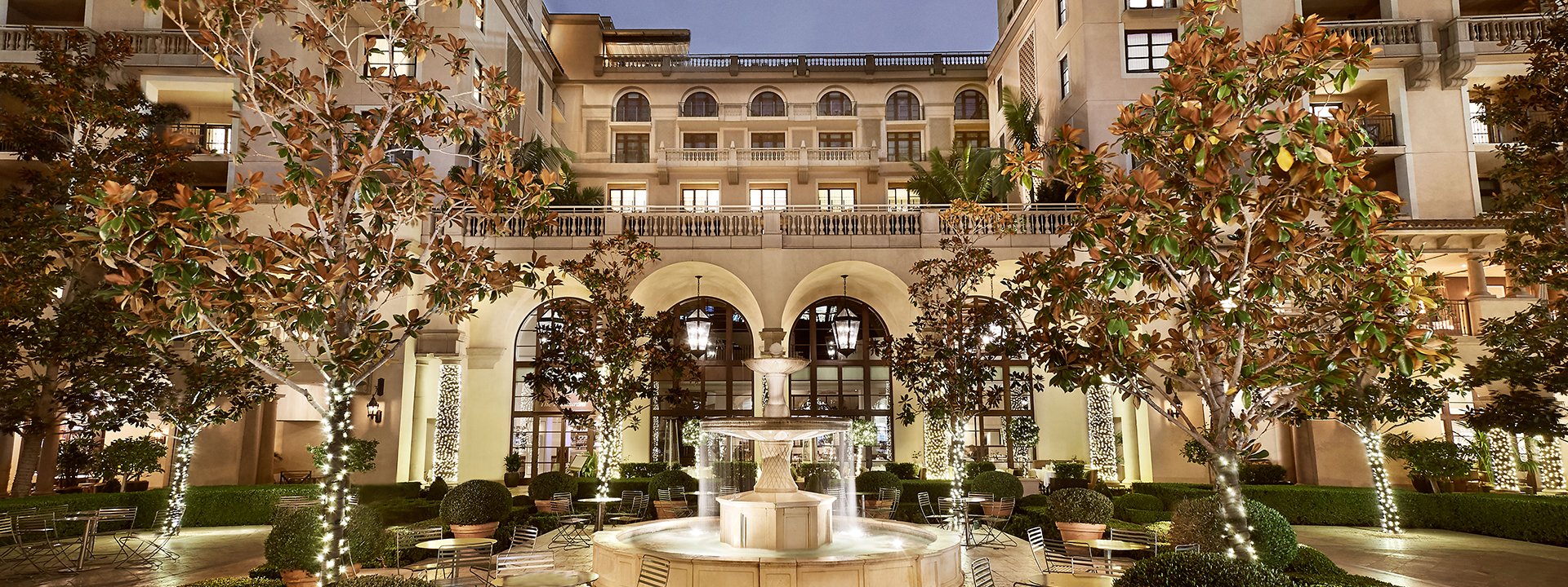 Evening view of the hotel through a lit Beverly Canon Gardens