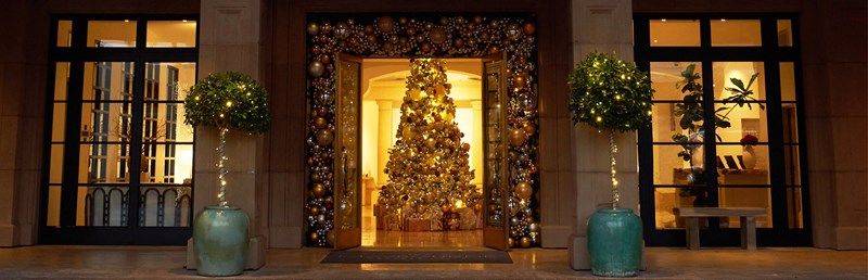 Christmas tree decorated in gold showing through the open double doors of the hotel's entrance