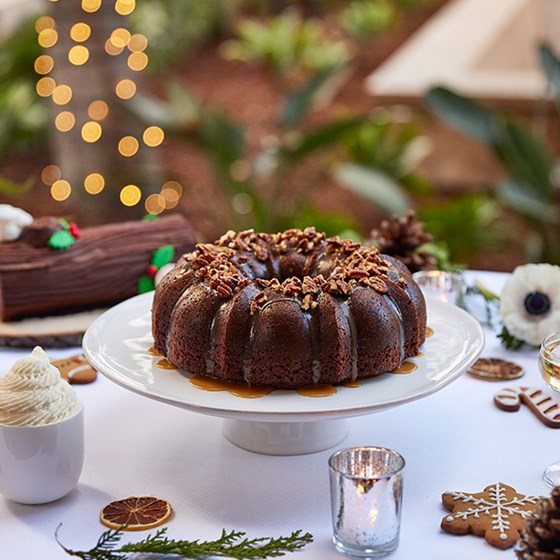 Chocolate bundt cake decorated with chocolate icing and sweet holly features for Christmas