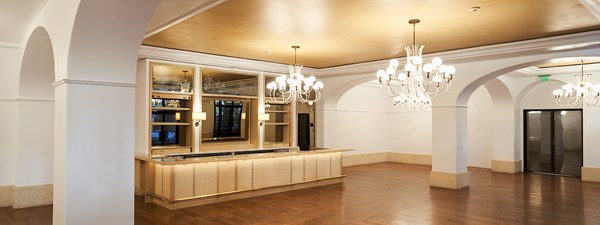 Empty event space with chandeliers and a built in-bar