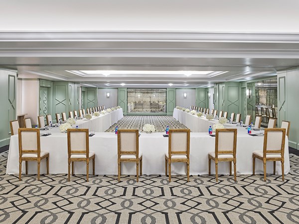 Chairs sat around a large horseshoe configuration desk in a meeting room