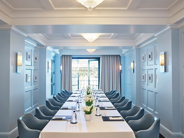 Blue chairs in a business meeting room gathered around a desk