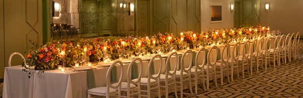 Long table with chairs and dinner settings placed for an event inside the hotel