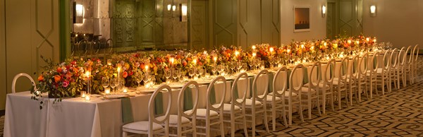 Long table with chairs and dinner settings placed for an event inside the hotel