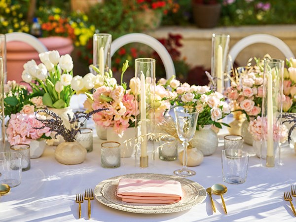Pink and cream flowers arranged on a tablescape at a wedding
