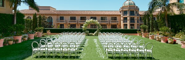 The Garden Terrace - garden set up for a wedding with chairs, an aisle in the middle and flower arch