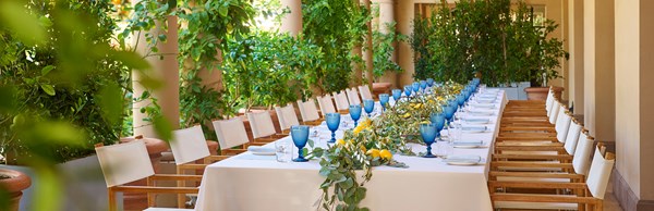 Long table set up for private dining event with lemons and greenery in the middle