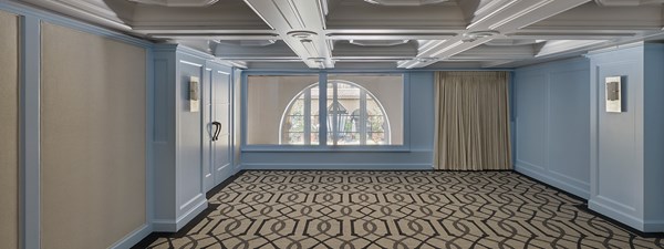 Wilshire event space with blue walls, pattern carpet and wide windows