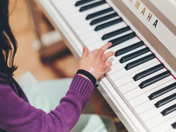 Close up of child playing piano