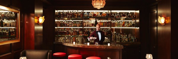 The Cigar and Whiskey bar - barman pouring a drink at a bar