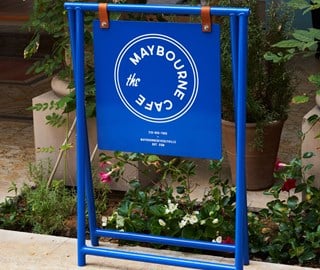 The Maybourne Cafe blue a-frame sign on a patio