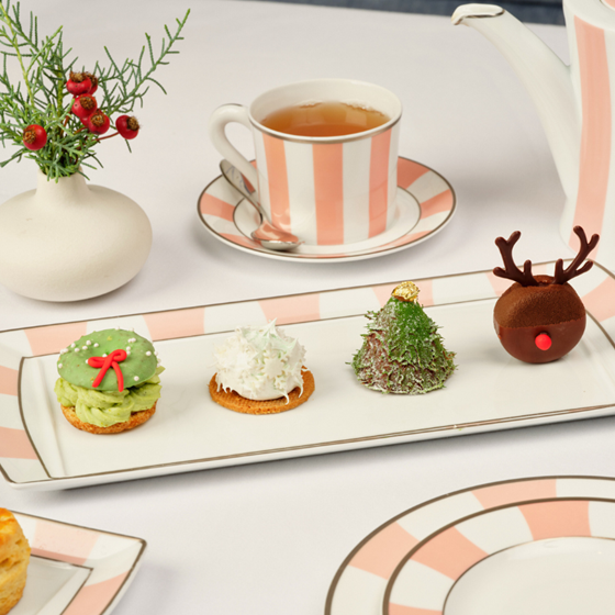 a festive afternoon tea set-up with holiday inspired pastries as a snowflake, reindeer, christmas tree, and festive wreath