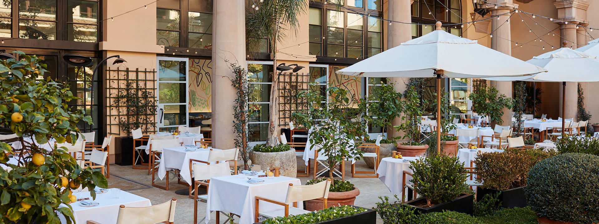 The restaurant's alfresco dining space is adorned with abundant greenery, creating a charming ambiance.