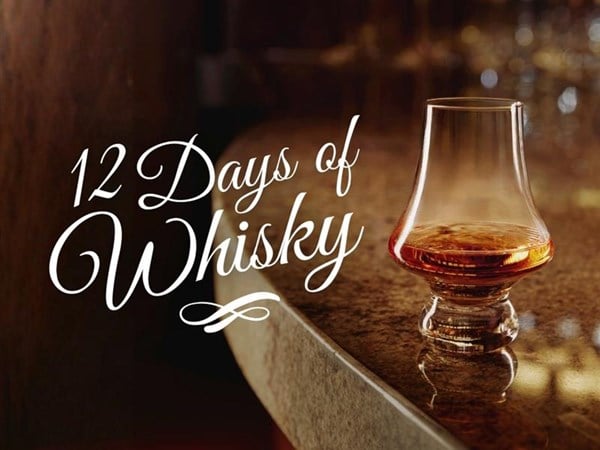 a whisky glass with a pour of whisky and a calligraphy writing of 12 days of whisky on the left