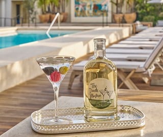Martini on a silver tray with swimming pool in the background