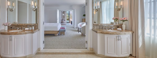 Two vanity sinks in the bathroom of the California Suite hotel room. There are large doors that open to the bedroom.