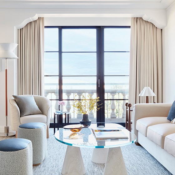 Sofa by window, sleek glass coffee table, modern elegance in a minimalist setting.