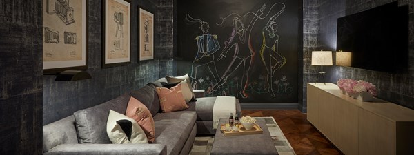 Lounge and TV with dark grey walls and modern artworks in The Residence