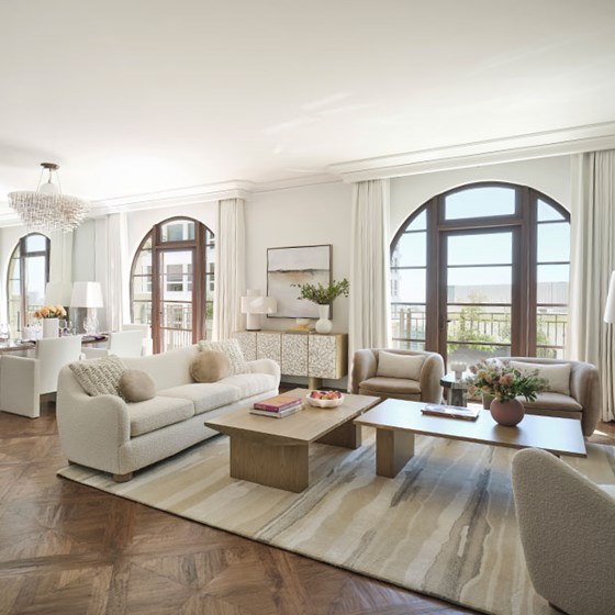 Large open-plan living space with a cream and nude colour palette and double balcony doors