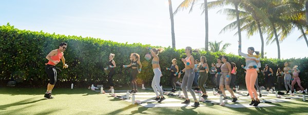 Fitness instructor teaching a class on a lawn outdoors