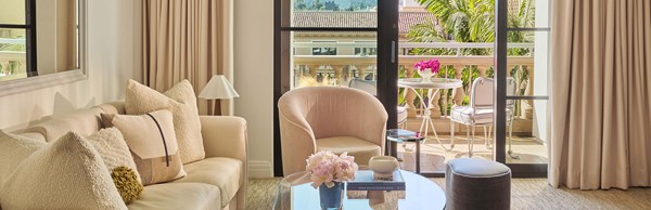 Suite living area with open terrace doors and beige furniture