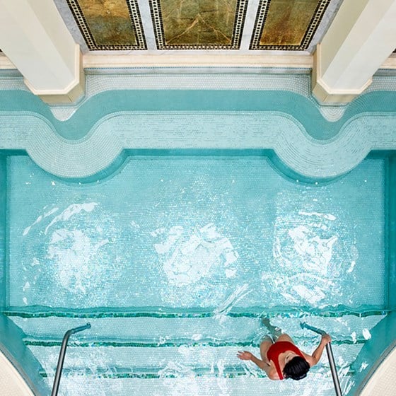 A woman stepping in the pool at The Maybourne Beverly Hills spa