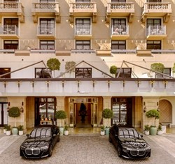 two bmw cars parked outside of maybourne beverly hills